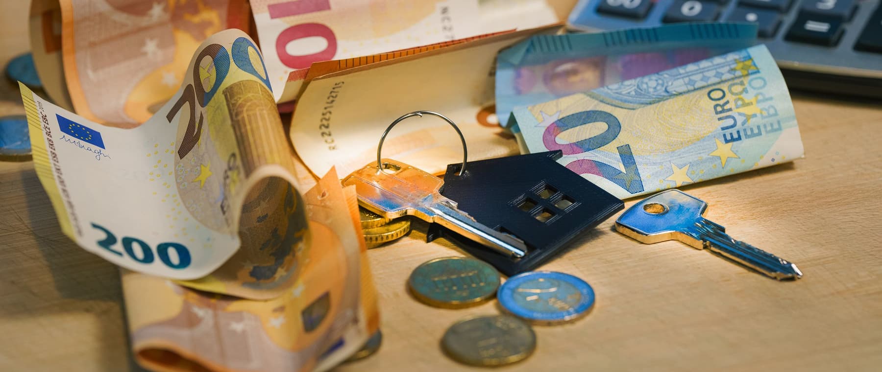Eurobiljetten en munten naast een rekenmachine